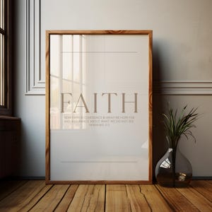 May include: A framed print with the word "FAITH" in a serif font. Below, the text reads "NOW FAITH IS CONFIDENCE IN WHAT WE HOPE FOR AND ASSURANCE ABOUT WHAT WE DO NOT SEE. HEBREWS 11:1." The frame is wood-toned, and the background is a neutral color.