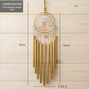 Puede incluir: Carrill&oacute;n de viento dorado con dise&ntilde;o de &aacute;rbol y piedras transparentes. La longitud total colgante es de 48 cm, con un ancho de 13 cm y una altura de 36 cm. El carill&oacute;n tiene m&uacute;ltiples tubos dorados y cuentas decorativas.