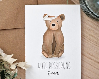 May include: A watercolor get-well card featuring a brown bear with a bandage on its head. The bear is sitting with its legs crossed. The card has the words "Gute Besserung Oma" written in black script.