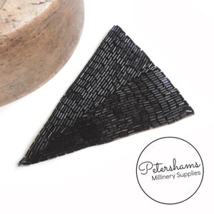 May include: Black triangle-shaped beaded embellishment. The beads are small and rectangular, creating a geometric pattern.