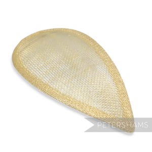 Peut inclure: Un couvre-chef doré en forme de goutte d'eau avec une texture tissée. Le couvre-chef a un bord défini et un sommet légèrement arrondi. Le nom de la marque "PETERSHAMS" est visible dans le coin inférieur droit.