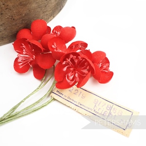 以下が含まれることがあります： 緑色の茎に赤い布の花が束ねられており、タグには「Made in German Democratic Republic 2219 917868 Petershams」と記載されています。