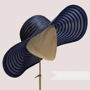 May include: A wide-brimmed blue sun hat with a striped pattern. The hat is made of a woven material and has a slightly curved brim.
