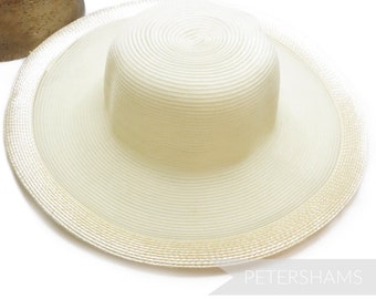 May include: A cream-colored sun hat with a wide brim and a cylindrical crown. The hat is made of woven material, with a textured surface. The brim measures approximately 15 inches in diameter. The hat is suitable for sun protection.
