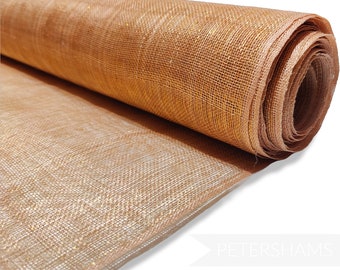 May include: A roll of gold and brown metallic mesh fabric. The fabric has a woven texture and is rolled up tightly.