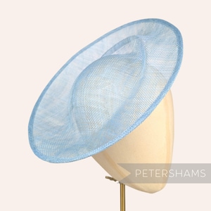 May include: A light blue, wide-brimmed hat made of a delicate, woven material. The hat is displayed on a hat stand.