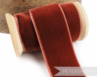 Könnte beinhalten: Eine Spule mit rostfarbenem Samtband. Das Band ist um eine Holzspule gewickelt und der Text "PETERSHAMS" ist auf das Band gedruckt.