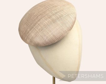 May include: A beige straw hat with a round crown and a slightly curved brim. The hat is displayed on a white hat stand.