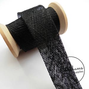 May include: Black mesh ribbon on a wooden spool. The ribbon has a textured, woven look.
