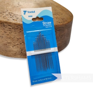 May include: A blue and white package of 16 straw needles, size 3/9, made in Great Britain. The package is labeled "Toota S550 Straw 16 Needles Size 3/9".