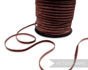 Könnte beinhalten: Eine Spule braunen Samtbandes mit schwarzem Kern. Das Band ist abgewickelt und zeigt seine Textur und Farbe. Das Petershams-Logo ist in der unteren rechten Ecke sichtbar.