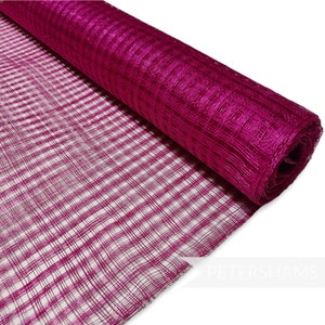 Puede incluir: Un rollo de cinta de malla a cuadros de color magenta. La cinta está hecha de un material fino y tejido y tiene un acabado ligeramente brillante.