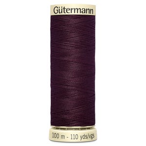May include: A spool of Gütermann sewing thread in a deep burgundy color. The label indicates 100 meters or 110 yards of thread. The thread is tightly wound on a white and cream-colored spool, ideal for various sewing projects.