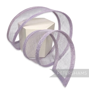 May include: A lavender-colored ribbon with a mesh weave and a satin edge is draped over a white geometric block. The ribbon is in a spiral shape, with the end of the ribbon pointing towards the bottom right corner. The word "PETERSHAMS" is printed on the bottom right.
