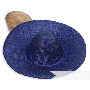 May include: A large, wide-brimmed sun hat made of woven straw in a deep blue colour. The hat is slightly curved and has a wide, flat brim.