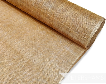 May include: A roll of gold metallic burlap fabric. The fabric has a woven texture and a subtle shimmer.