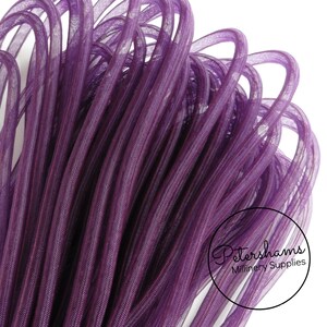 May include: A close-up of a spool of purple mesh ribbon. The ribbon is soft and pliable, and it has a subtle sheen.