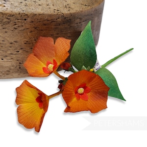 May include: A bouquet of three orange silk flowers with red centers. The flowers are arranged on a green stem with leaves.