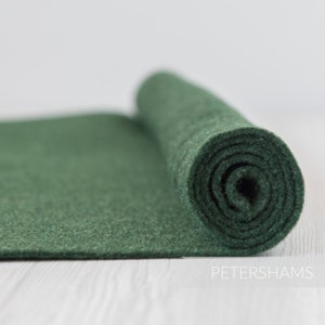 May include: A roll of dark green felt fabric. The felt is rolled up tightly and the edges are visible.