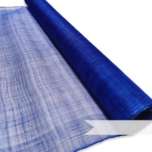 May include: A roll of deep blue fabric, partly unrolled to show its woven texture. The fabric has a slightly transparent look, with a clear grid pattern. The material is a rich blue, and the roll is angled against a white background. The fabric is suitable for various craft projects.