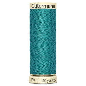 Pode incluir: Uma bobina de linha de costura Gütermann turquesa. A bobina cilíndrica tem uma base e uma parte superior brancas, e a linha é cuidadosamente enrolada. O rótulo exibe "Gütermann" e "100 m - 110 yds/vgs".