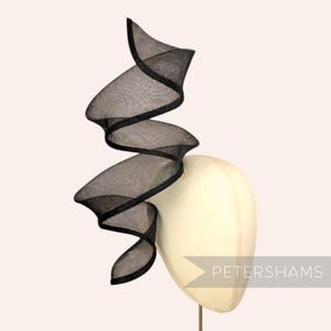 Peut inclure: Une tasse en céramique blanche avec une anse noire et le texte "But First, Coffee" en gras noir. La tasse est remplie d'un liquide foncé, probablement du café, et repose sur une surface claire.