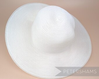May include: A white sun hat with a wide brim and a slightly rounded crown. The hat is made of a woven straw-like material.