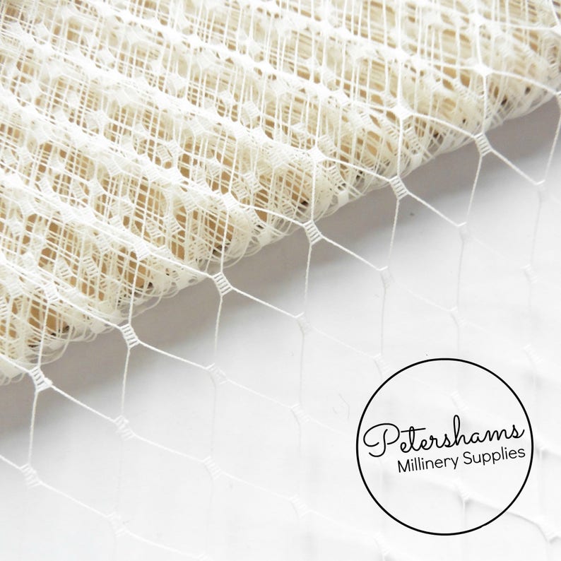 May include: White bridal illusion tulle netting fabric with a delicate diamond pattern. This netting is perfect for millinery and craft projects.