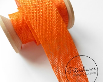 May include: Orange netting ribbon, a type of craft supply used for decorating and crafting. The ribbon is rolled on a wooden spool.