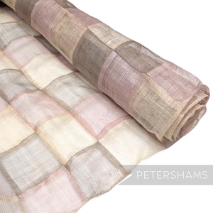 May include: A rolled-up fabric with a patchwork design. The squares are in shades of pink, beige, and gray. The fabric has a woven texture and appears to be lightweight. The word "PETERSHAMS" is visible in the bottom right corner.