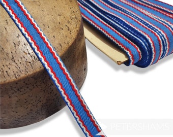 May include: Blue, white, and red striped ribbon with a zig-zag edge. The ribbon is wound around a wooden spool.