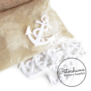 May include: A bag of white embroidered anchor appliques. The anchors are in various sizes and are perfect for adding a nautical touch to crafts and projects. Petershams Millinery Supplies.
