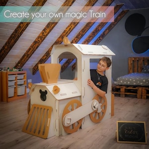 May include: A cardboard train with white and tan accents. The train has a Mickey Mouse silhouette on the front and the text "Create your own magic Train" at the top. A child is looking out of the train window.