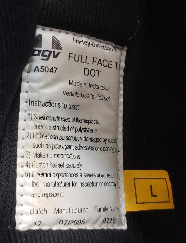 Peut inclure: Gros plan sur une &eacute;tiquette de casque int&eacute;gral Harley-Davidson. L'&eacute;tiquette comprend le logo de la marque, des informations sur le mod&egrave;le et des instructions de s&eacute;curit&eacute;. Une &eacute;tiquette jaune avec la lettre "L" indique la taille du casque.
