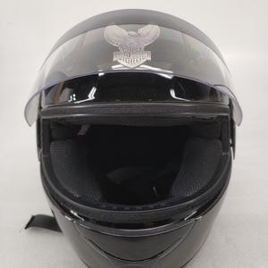 Peut inclure: Casque de moto noir avec une visi&egrave;re transparente. Le casque porte le logo Harley-Davidson. Le rembourrage int&eacute;rieur est noir. Con&ccedil;u pour prot&eacute;ger la t&ecirc;te pendant la conduite &agrave; moto.