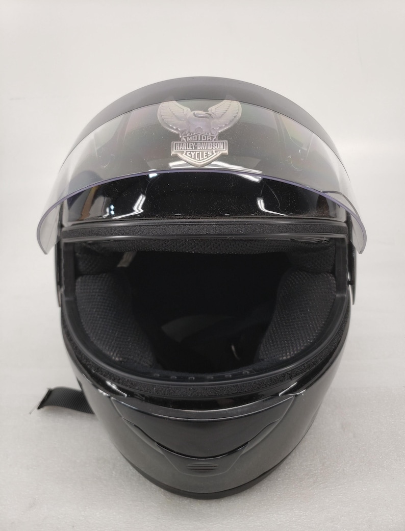Peut inclure: Casque de moto noir avec une visi&egrave;re transparente. Le casque porte le logo Harley-Davidson. Le rembourrage int&eacute;rieur est noir. Con&ccedil;u pour prot&eacute;ger la t&ecirc;te pendant la conduite &agrave; moto.