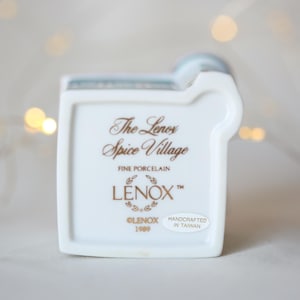 K&ouml;nnte beinhalten: Wei&szlig;e Porzellanfigur eines Hauses mit einer goldenen Inschrift, die lautet "The Lenox Spice Village Fine Porcelain Lenox&trade; Lenox 1999 Handcrafted in Taiwan"