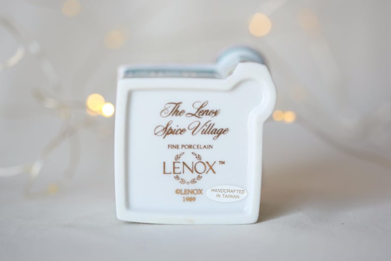 K&ouml;nnte beinhalten: Wei&szlig;e Porzellanfigur eines Hauses mit einer goldenen Inschrift, die lautet "The Lenox Spice Village Fine Porcelain Lenox&trade; Lenox 1999 Handcrafted in Taiwan"