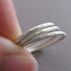 Puede incluir: Tres anillos apilables de plata martillados. Los anillos son finos y tienen una superficie texturizada.