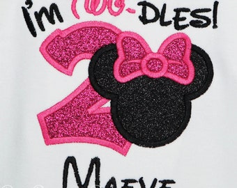 May include: Pink and black glittery Minnie Mouse themed birthday shirt with the text "I'm Two-dles!" and the name "Maeve" written below.