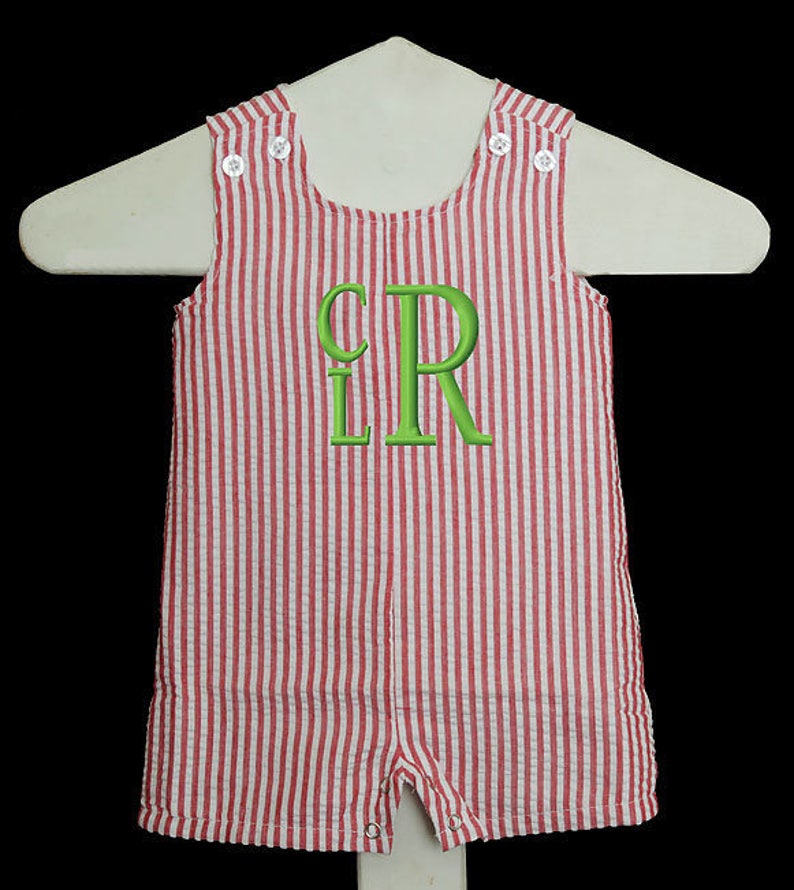 May include: Red and white striped baby overalls with a green embroidered monogram "LR" on the front.