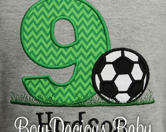 May include: Green and white chevron number nine with a black and white soccer ball on a gray background. The text "Bow Dacious Baby" is below the number and soccer ball.