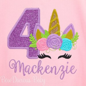 Puede incluir: N&uacute;mero cuatro de purpurina morado con una cabeza de unicornio con un cuerno dorado y una corona de flores con flores rosas, moradas, azules y verdes. El texto "Mackenzie" est&aacute; debajo del unicornio y el texto "Bow Dacious Baby" est&aacute; debajo de ese.