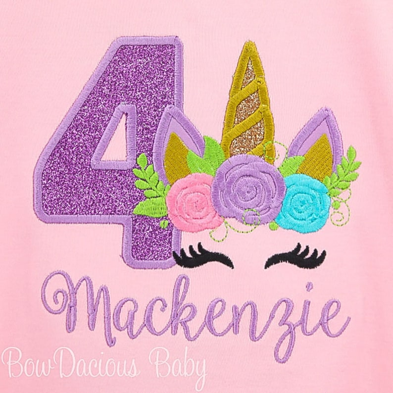 Puede incluir: N&uacute;mero cuatro de purpurina morado con una cabeza de unicornio con un cuerno dorado y una corona de flores con flores rosas, moradas, azules y verdes. El texto "Mackenzie" est&aacute; debajo del unicornio y el texto "Bow Dacious Baby" est&aacute; debajo de ese.