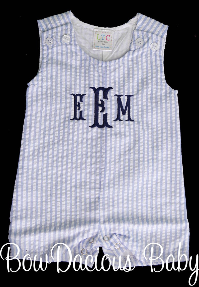 May include: A blue and white striped baby onesie with a navy blue monogram "EEM" on the front. The onesie has a sleeveless design and is made of a soft, comfortable fabric.
