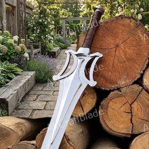 May include: A double-edged steel sword featuring a complex, stylized crossguard with open-work detailing and a brown leather-wrapped grip. The blade has a central ridge and a pointed tip, with a metallic pommel at the base of the handle.