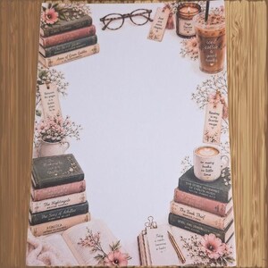 May include: A stationery sheet featuring a white center border decorated with stacks of books, iced coffee, a candle, eyeglasses, and floral accents. Text includes "Iced coffee & good books," "Just one more chapter," and "So many books so little time."