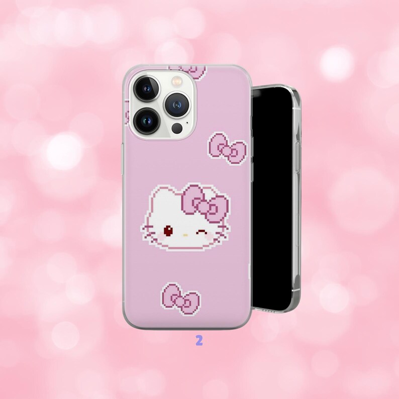 May include: A pink phone case featuring a pixelated Hello Kitty design with a bow and additional bow accents. The case is shown with a black smartphone, set against a soft pink background.