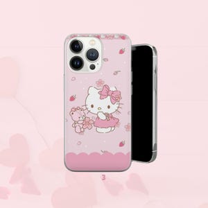 Puede incluir: Funda de tel&eacute;fono rosa con dise&ntilde;o de Hello Kitty. La funda presenta un lazo rosa, un vestido y un oso de peluche con flores. Tiene un borde transparente y un fondo rosa con fresas y flores. El n&uacute;mero "3" est&aacute; en la parte inferior.