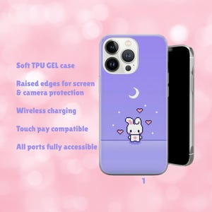 May include: A lavender phone case with a pixelated bunny design, a crescent moon, and hearts. The case has raised edges for screen and camera protection. The text on the case says "Soft TPU GEL case", "Wireless charging", and "Touch pay compatible".